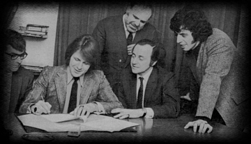 Carl signs the record deal.